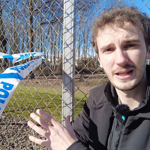 Man vid stängsel med polisavspärrningsband i bakgrunden.