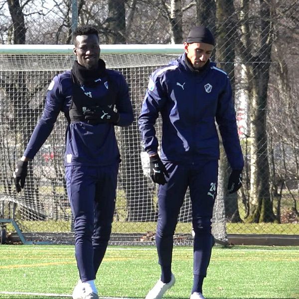 Naeem Mohammed och Amir Al-Ammari går i träningskläder över en fotbollsplan