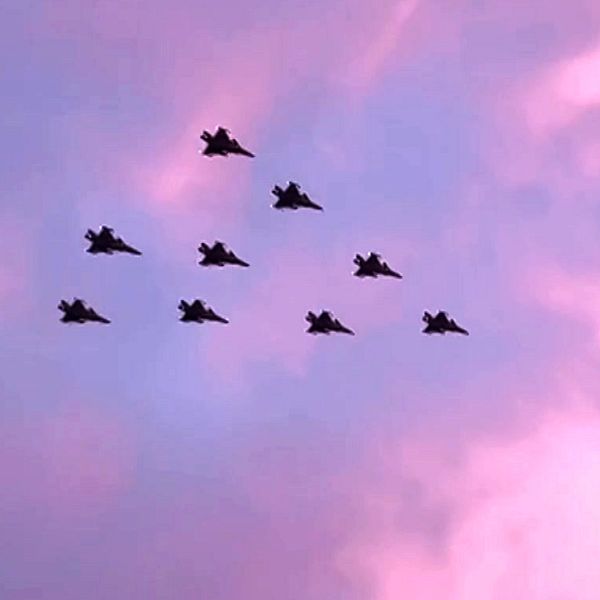 Nio stridsflygplan flyger i en julgransliknande formation mot en blårosa himmel i Norrbotten
