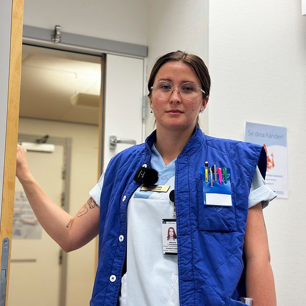 Sjuksköterskan Amanda Ljungberg står lutad mot en dörr på buk- och kärlkirurgiska avdelningen i Umeå