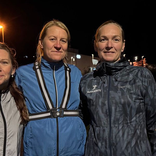 Tre löpare står tillsammans utomhus i mörkret vid Rocksjön i Jönköping.