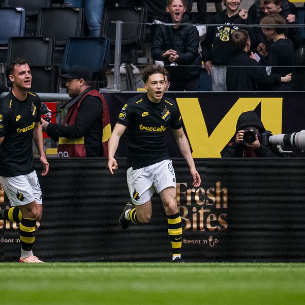Två AIK-spelare firar ett mål inför jublande supportrar på fotbollsstadion.