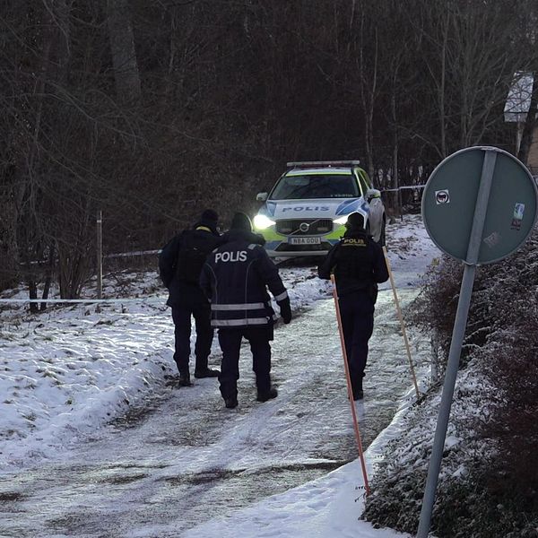 Tre poliser går mot polisbilen som står på den avspärrade platsen efter polisattacken på Österängen i Jönköping.