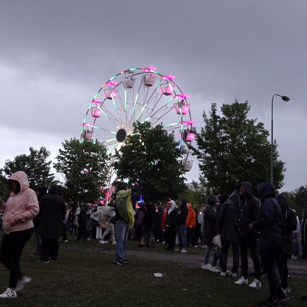 besökare på Alivefestivlaen i BOrlänge, och ett parisehjul i bakgrunden
