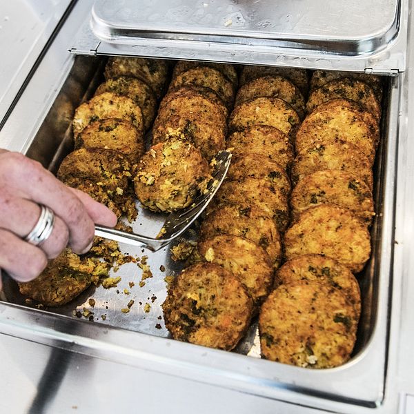 En bild från ett storkök med potatis och grönsaksbullar som ligger i en ugnsfast form