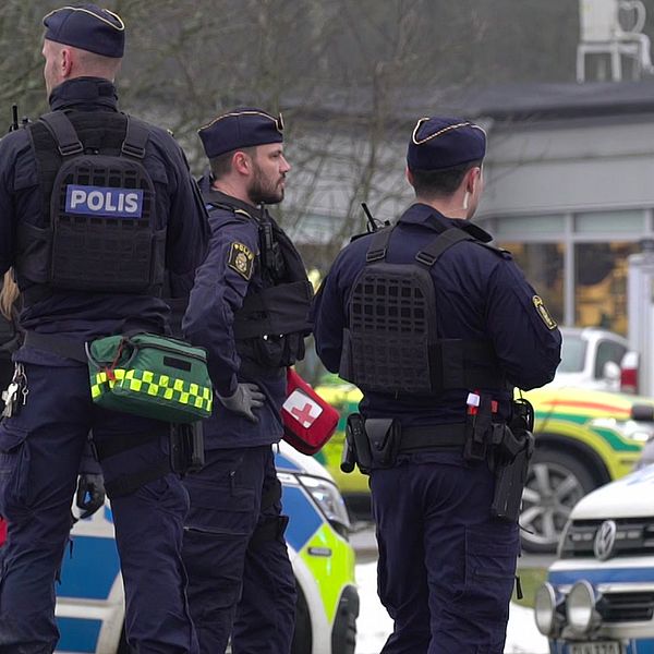 Fem polise står vid två polisbilar utanför den drabbade skolan i Örebro där flera människor sköts till döds i februari 2025.