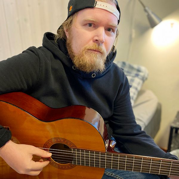 Johan Fridesjö bor på ett träningsboende i Luleå, på bilden spelar han gitarr.
