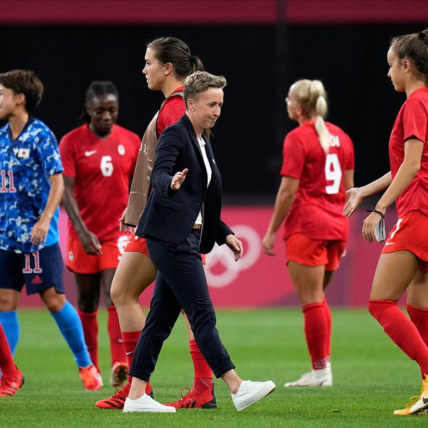 Förbundskaptenen Bev Priestman bland sina spelare vid OS i Tokyo där laget tog guld efter att ha besegrat Sverige efter straffar i finalen.