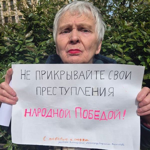 Ljudmila Vasiljeva håller upp en protestskylt mot kriget i Ukraina
