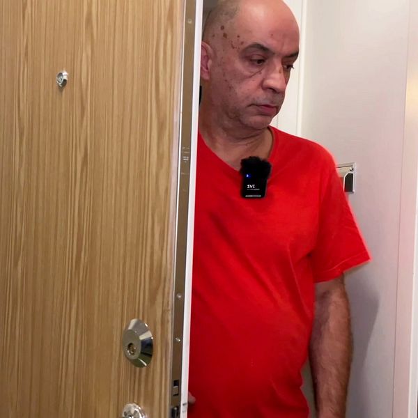Ebrahim Ebrahimi kliver genom en dörr i ett trapphus i Karlstad.