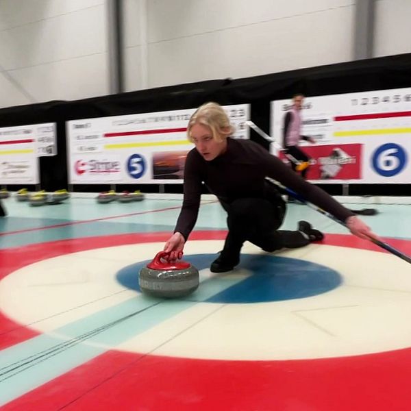 Curlingspelaren Emelie glider i väg längs isen.