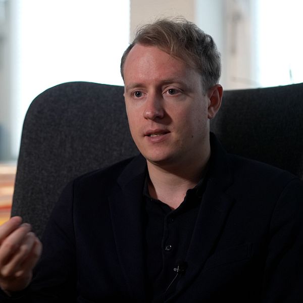 Expos researcher Morgan Finnsiö talar i en fåtölj framför bokhylla