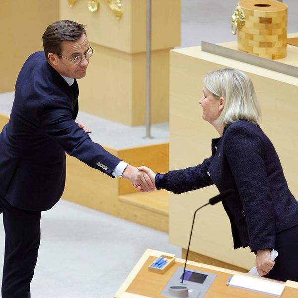 Andersson och Kristersson skakar hand i riksdagens kammare.