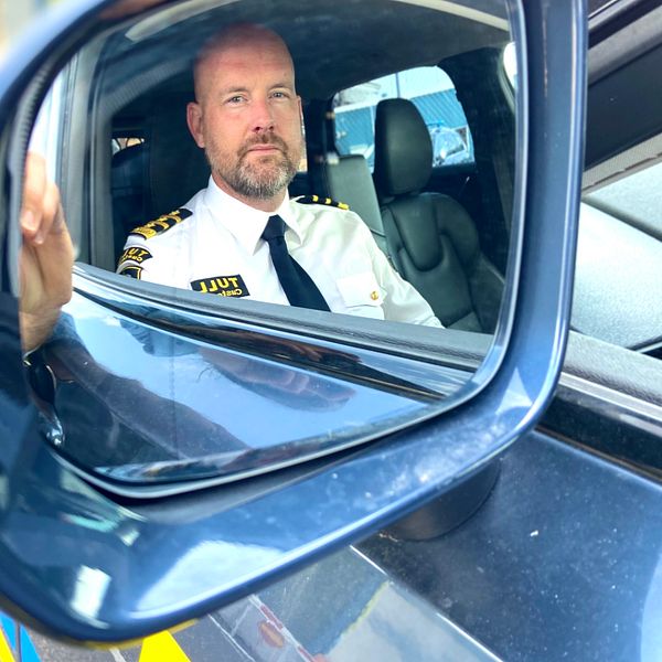 Tulltjänsteman som sitter i sin tullbil och spanar.