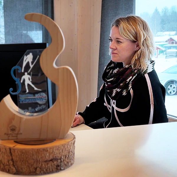 En blond kvinna sitter framför en datorskärm.