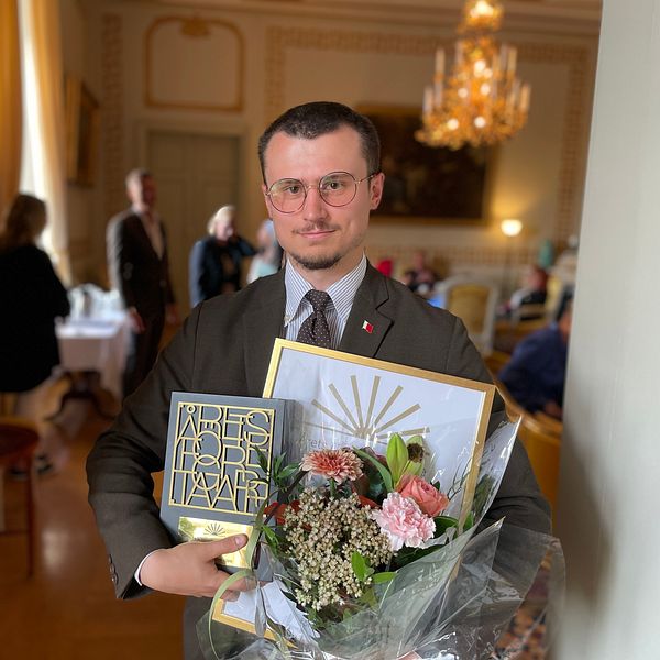 David Lundgren poserar med blommor och priser efter att ha vunnit årets unga företagare.