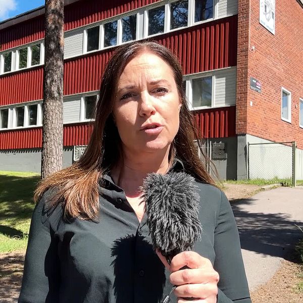 SVT-reportern Maria Haglund utanför en skolbyggnad med mikrofon