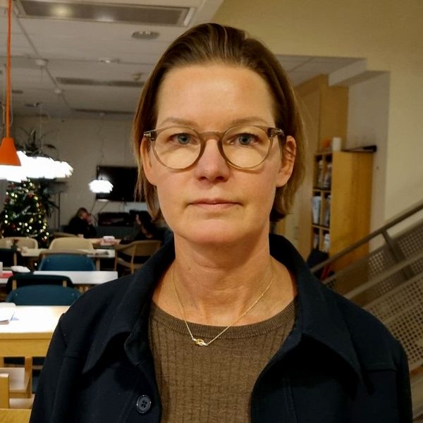 Verksamhetschefen Marie Åberg på Ivo tittar rakt in i kameran. Bakom syns bord och stolar och en trappa.