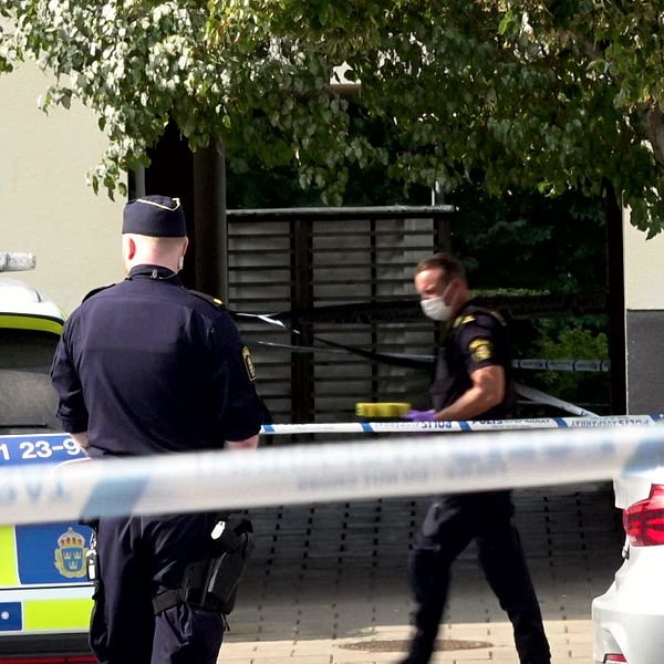 Avspärrningsband och två polisanställda.