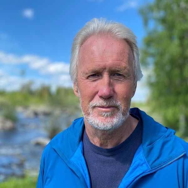 Gråhårig man med skägg står vid Gimån. Mannen, Ingemar Näslund, har blå jacka på sig.
