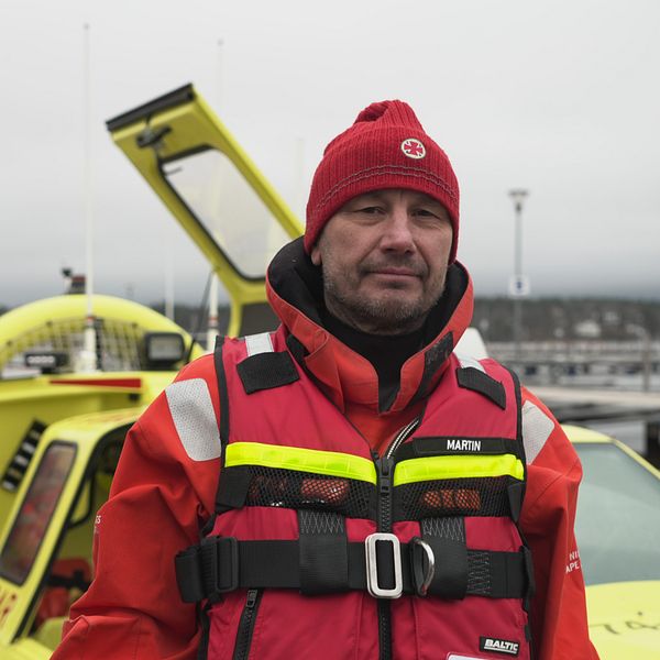 Martin Tengroth, frivillig sjöräddare står framför en svävare vid kaj.