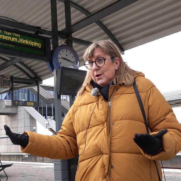 En man och en kvinna pratar med varandra på en tågstation.