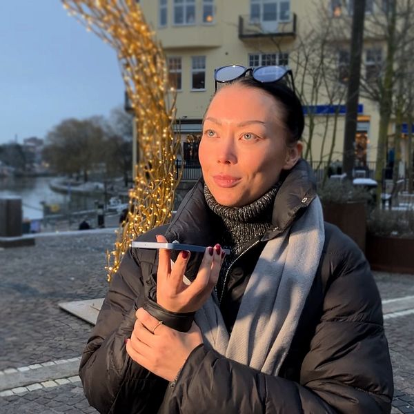 SVT:s reporter står och håller i sin mobiltelefon