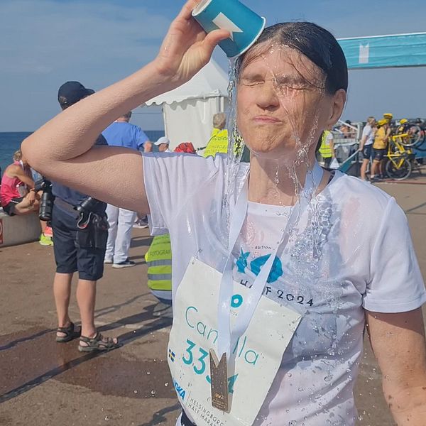 Maratonlöpare häller vatten över ansiktet