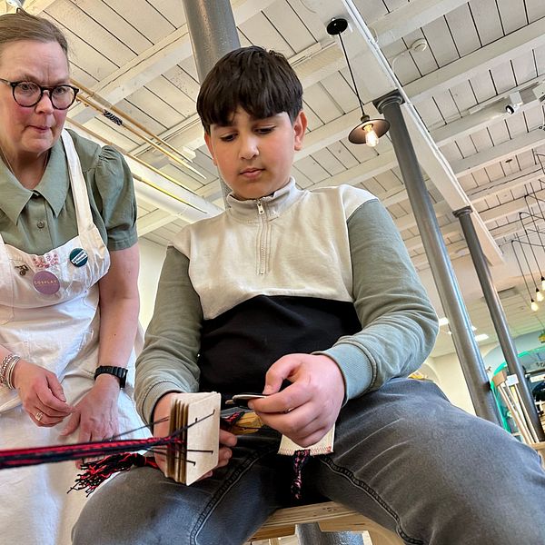 Barn gör egen polkagris tillsammans med instruktör på fabriksmuseum.