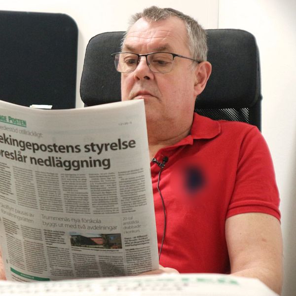 Blekingepostens chefredaktör Lars-Göran Enarsson sitter med en tidning.