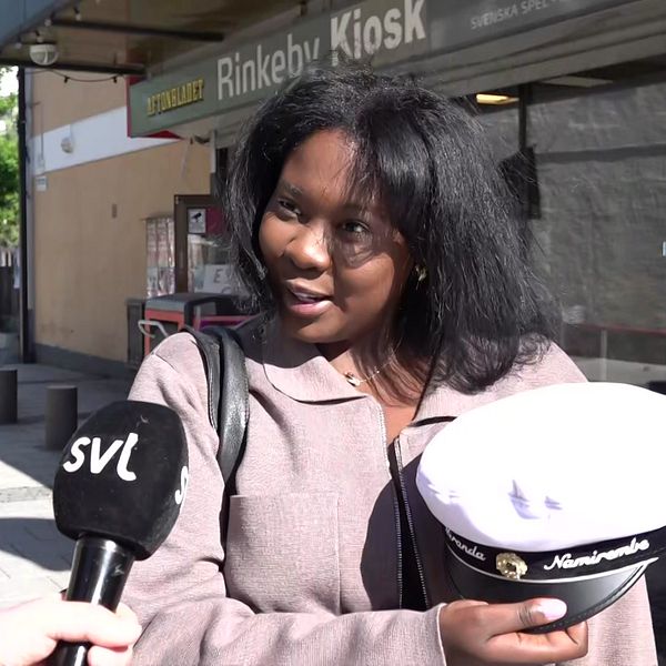 Tjej med studentmössa utanför Rinkeby kiosk.