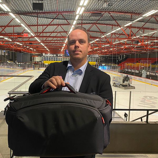 Kim Ahlqvist står framför hockeyplanen med en stor väska.