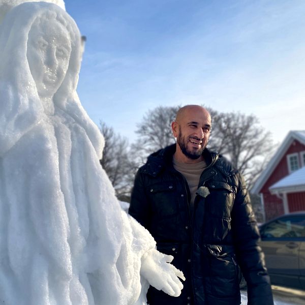 Konstnären Kamil Yacoub tillsammans med sin snöskulptur.