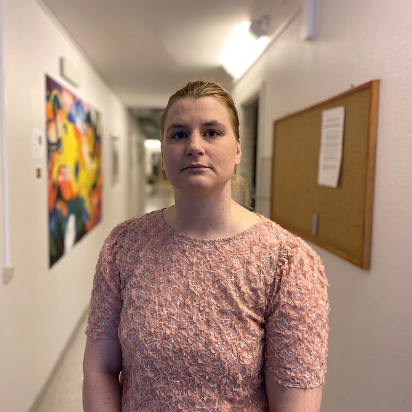 Malin Rimmö, rektor på Hansåkerskolan i Stugun står i en skolkorridor. Hon har blont uppsatt hår och är klädd i en rosa tröja med tygblommor fastsydda på.