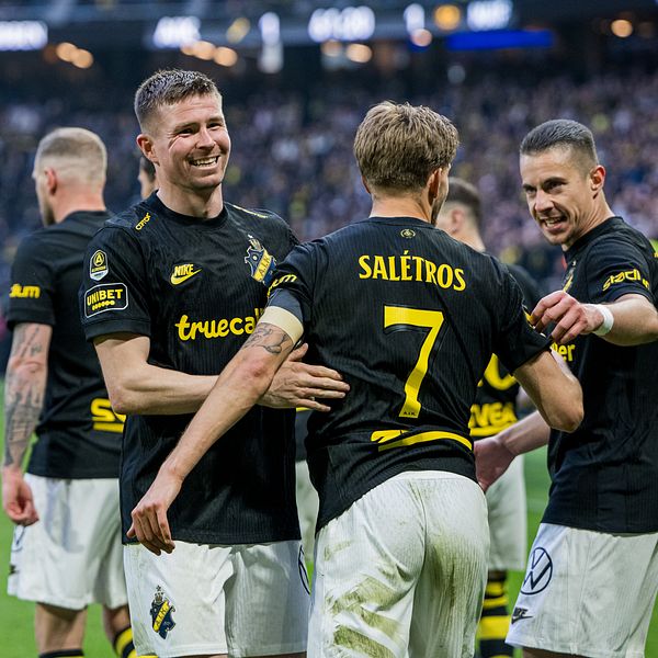 AIK-spelare samlade på planen under en fotbollsmatch inför fullsatta läktare.