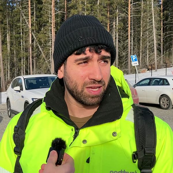 Ammar Soleman i neongul jacka vid en parkeringsplats vid northolt i Skellefteå.