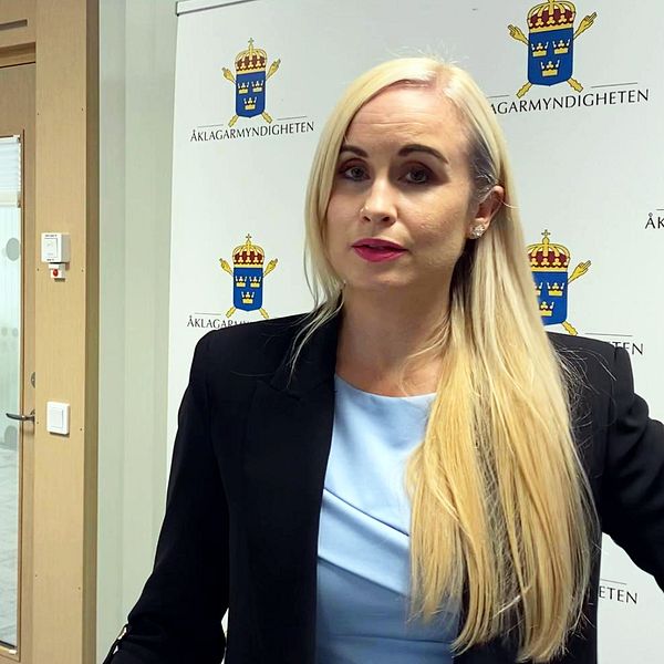 Åklagaren Karolina Lassbostår framför en vägg där det står ”åklagarmyndigheten”