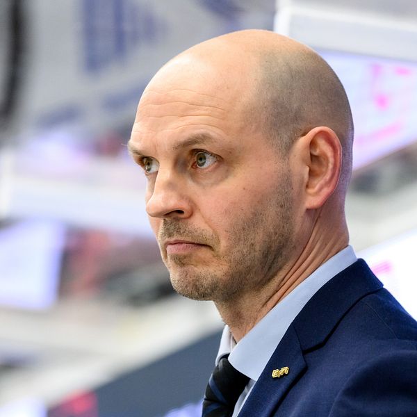 Person i kostym vid idrottsevenemang. Bakgrund med sportarena detaljer.