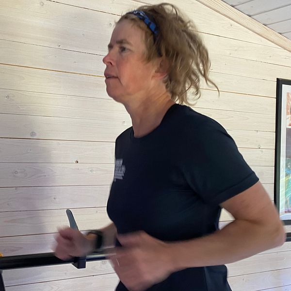 En löpare springer på löpband inomhus