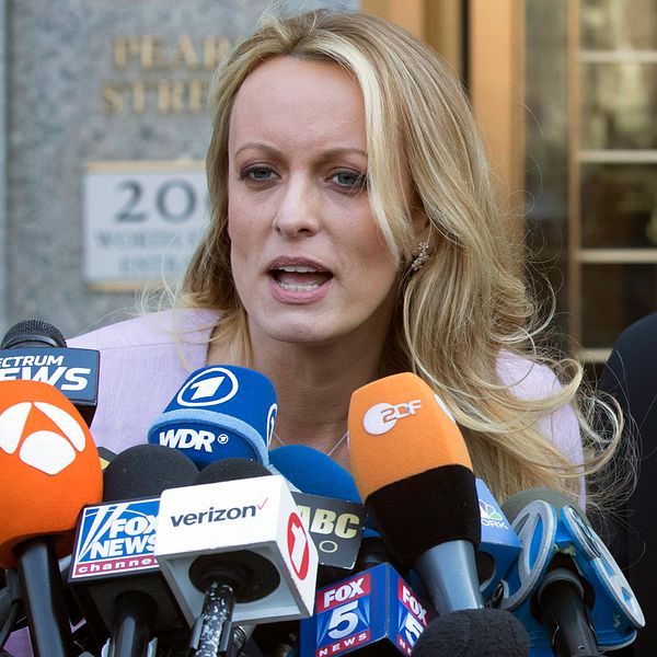 Stormy Daniels pratar framför journalister om åtalet mot Donald Trump.