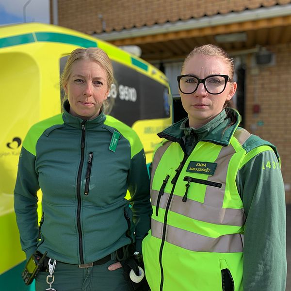 Två kvinnliga ambulanssjuksköterskor står framför ambulans.