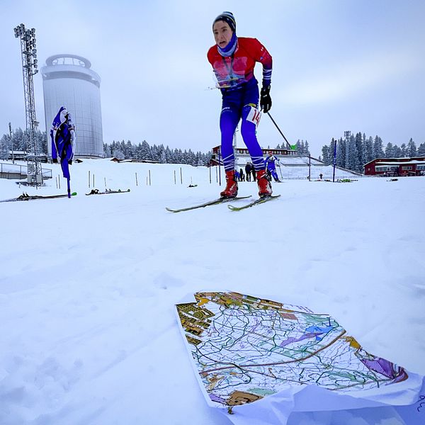 En kille åker skidor med ett kartställ, skidorientering, på Östersunds skidstadion.