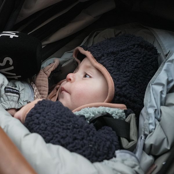 Ett barn i en barnvagn med SVT-mikrofon