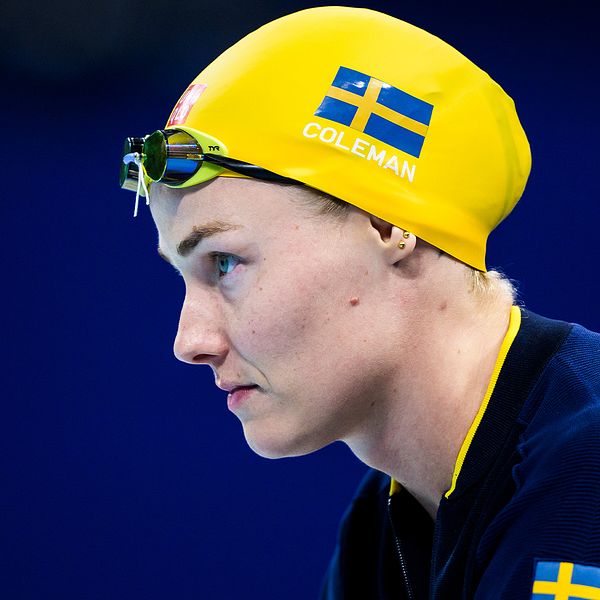 Simhoppare i gul simmössa med svenska flaggan.