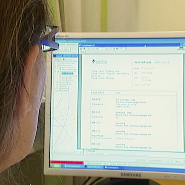 En sjukvårdspersonal tittar på en digital patientjournal på dataskärmen.