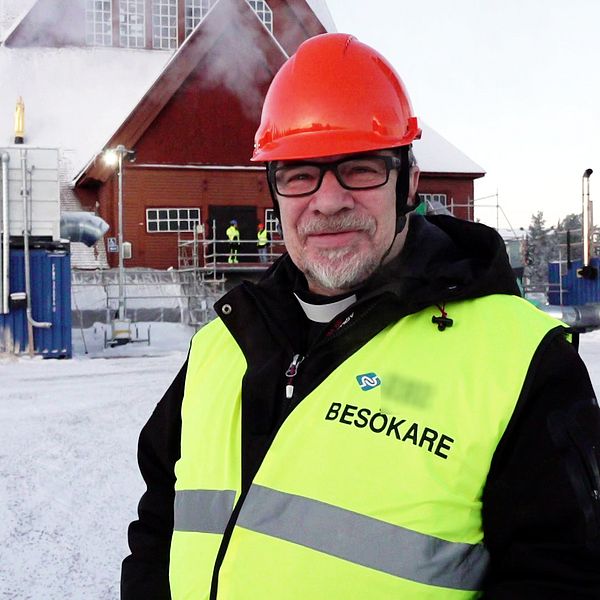 Man i gul väst står utanför Kiruna kyrka.
