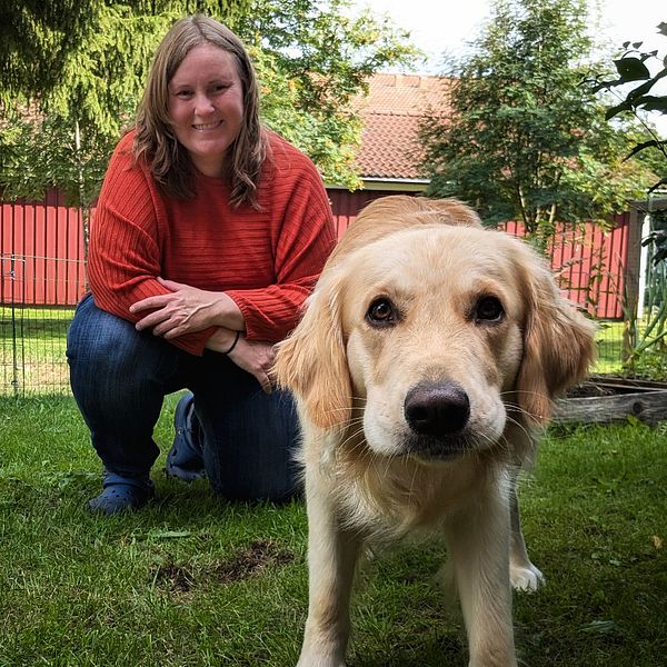 Andréa Olofsson sitter på knä i sin bakgård jämte sin hund Enzo