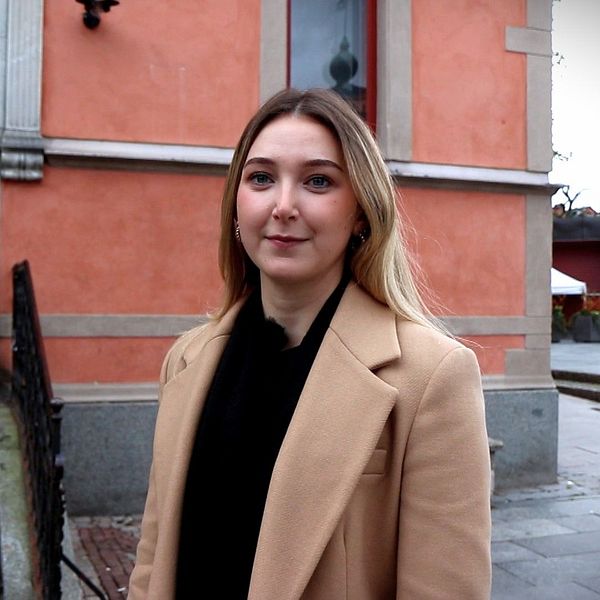 Kvinna framför gammalt hus