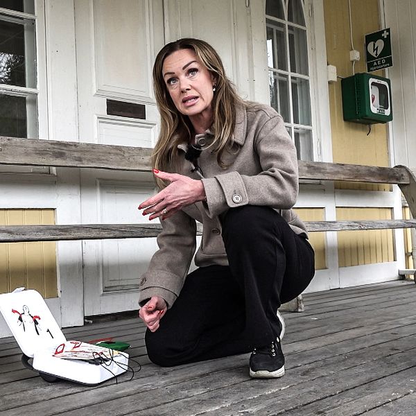 Carina Sparring visar en av de 17 hjärtstartare som hon varit med att sätta upp i Svärdsjöbygden.