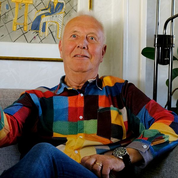 Ragnar Nordanstig i färgglad skjorta sitter i soffa och pekar under intervju